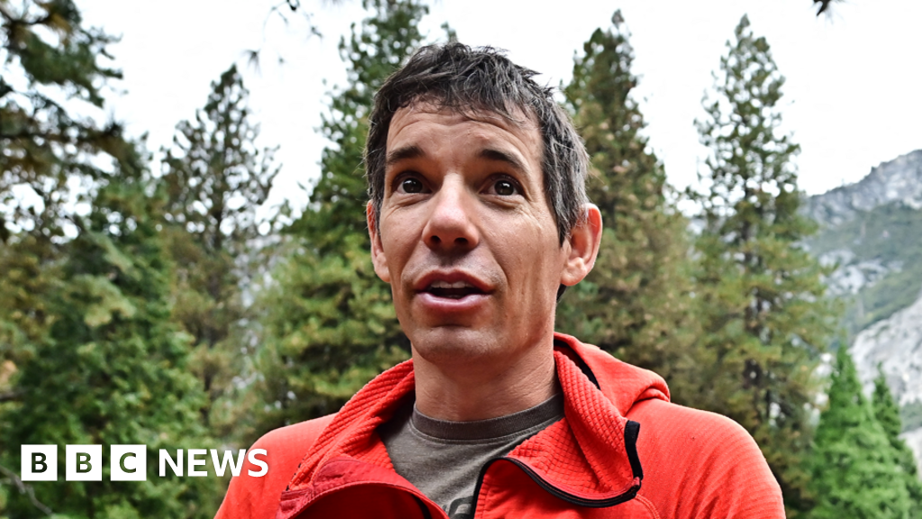 Climber delays rope-free skyscraper ascent over rain
